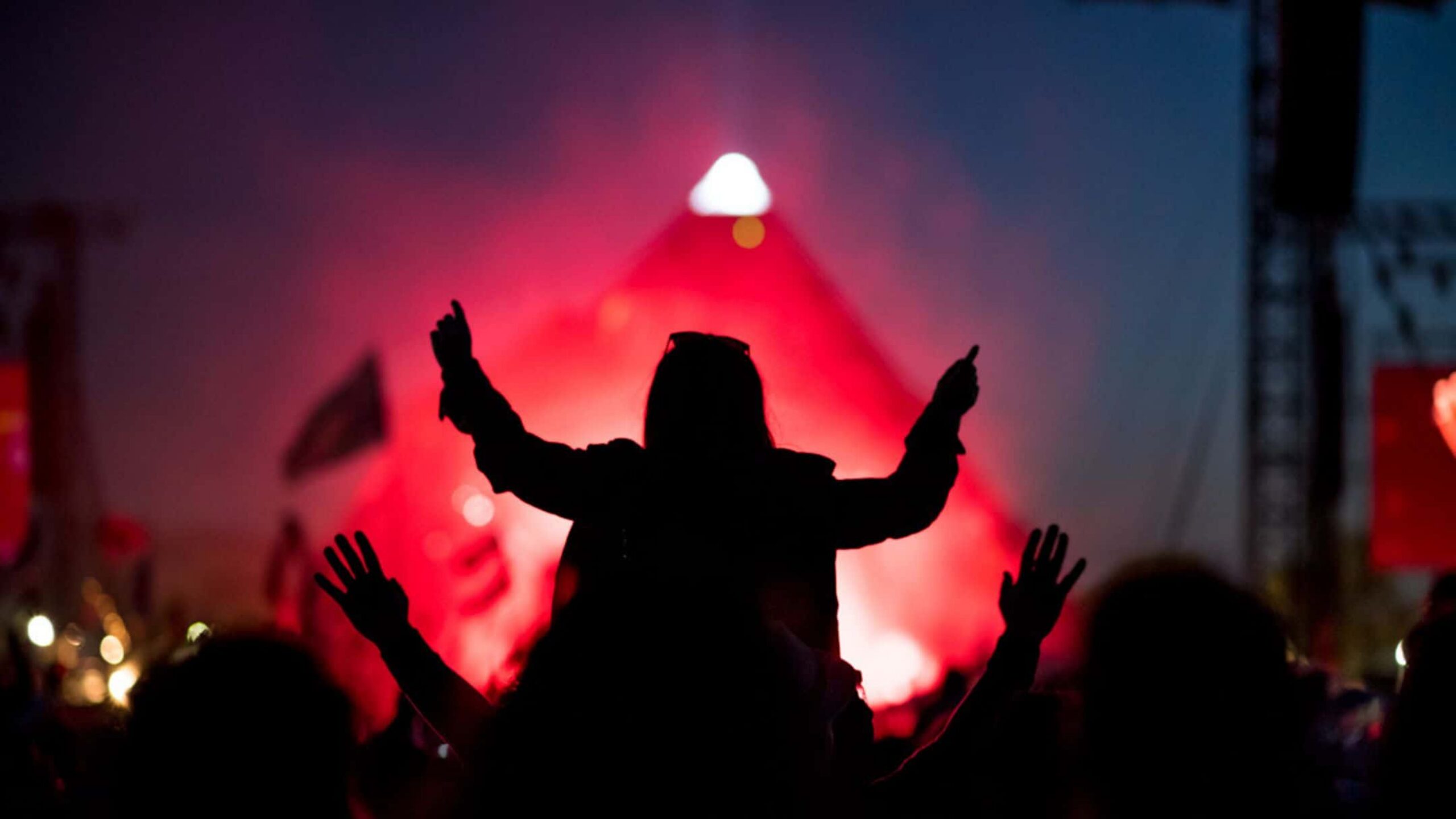 Festival crowd in front of a lit stage at night