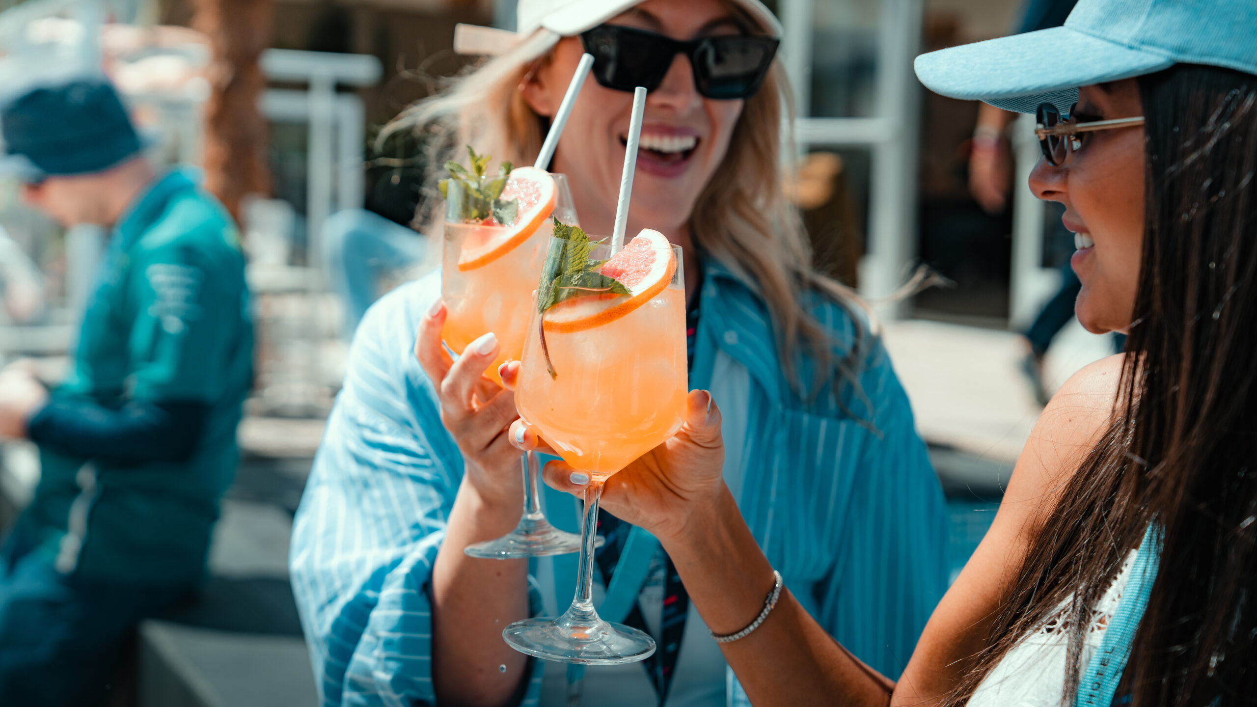 Two guests raising spritz cocktails in the sunshine