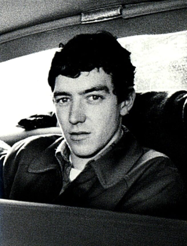 Tony McCarroll in the early Oasis years, black and white photo in the back of a car